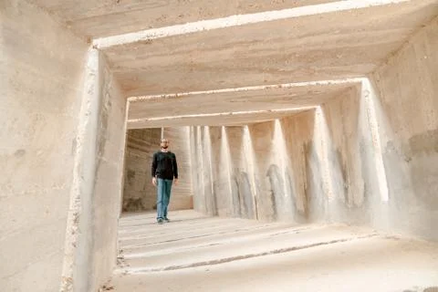 Front view of man walking alone in tunnel corridor. Urban underground lonely  Stock-Fotos