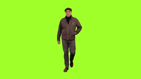 Front view of a man walks and talking on a smartphone on green screen background Video stock 71757945