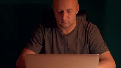 Front view man working on laptop at night. Low key dark background. Man coding Stock Footage 82589902