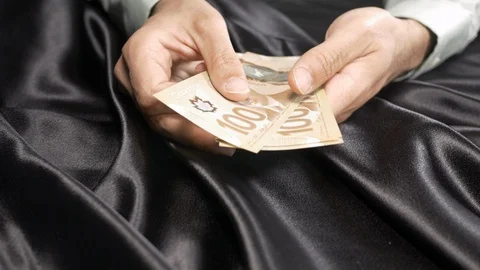 Front view of a mans hand counting and throwing Canadian money on the table 4k. Stockbeeldmateriaal 96051958