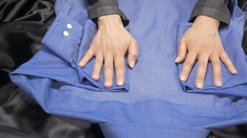 Front view-merchandiser folding a blue luxury businessman shirt 4k. Stock Footage 96289216