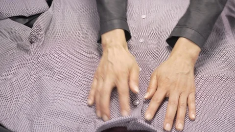 Front view-merchandiser unbuttoning a luxury businessman burgundy dress shirt Stock Footage 96289818