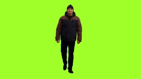 Front view middle aged man in winter clothes walking on green background Video stock 84680166