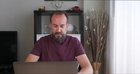 Front view of middle-aged man working with his laptop seated at a table next Stock Footage 155276629