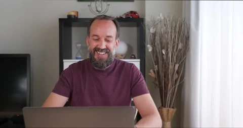 Front view of middle-aged man with beard in a video conference at home Stock Footage 160680305