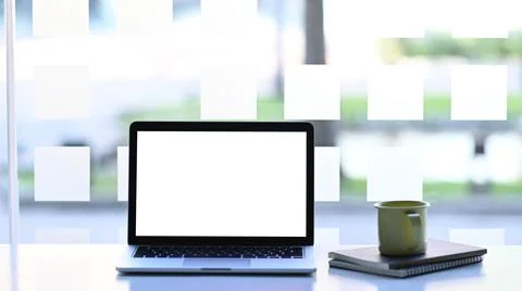 Front view of mock up laptop computer, notebook and coffee cup on white table Stock Photos