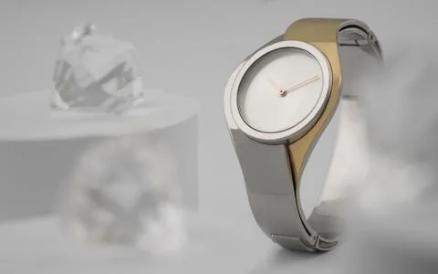 Front view of modern design silver gold hand watch between brilliants on whit Stock Photos