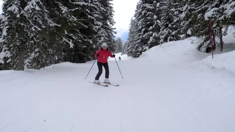 Front view in motion of woman skiing down snow mountain slope across pine forest Stock-Footage 319856248