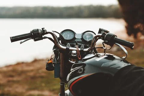Front view motorcycle on a sandy beach on the background of the coast Stock Photos