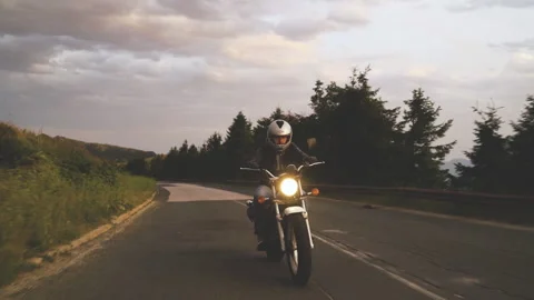 Front view of Motorcyclist on mountain road with open helmet riding vintage Stock Footage 159059193
