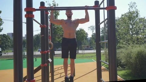 Front view of a muscular man doing pull up exercises Stock Footage 79051944