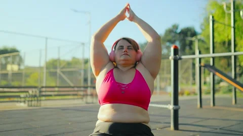 Front view of an obese plus size woman doing fitness stretching on a mat. Stock Footage 344249500