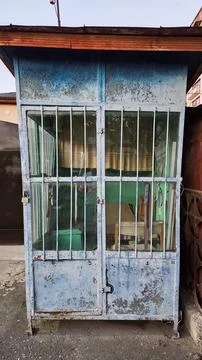 Front View of Old Blue Metal Kiosk with Window Bars Stock Photos