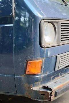 Front view of old blue vintage van with rusty bumper and round headlight Stock Photos