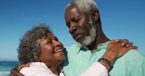Front view old couple looking at the camera at the beach Видео 125719444