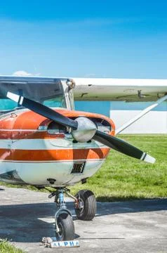 Front view of old red and white single engine propeller plane on grass field. Stock Photos