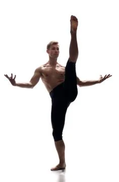 Front view, one young man, ballet dancer, standing on one leg, other leg in h Stock Photos