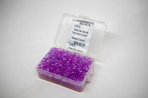 Front view of an open clear plastic container filled with purple silica gel.. Stock Photos