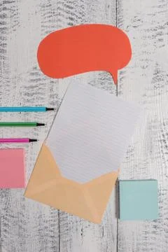 Front view open envelop speech bubble paper sheet ballpoints notepads lying Stock Photos