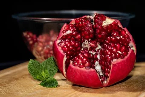 Front view of opened pomegranate with mint leaves and bawl of seeds Stock Photos
