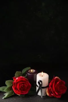 Front view of pair of candles red flowers on a dark background evil war dea.. Stock Photos