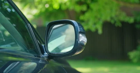 Front view of passenger side rear view mirror of a parked luxury car closing Stock Footage 199653892