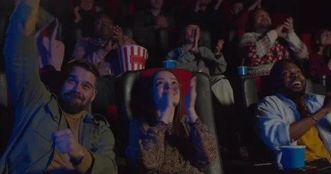 Front view of people applouding at end of good film in movie theatre. Excited Stock Footage 141710633