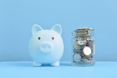 Front view of piggy bank and coins. Retirement, save money and investing conc Stock Photos