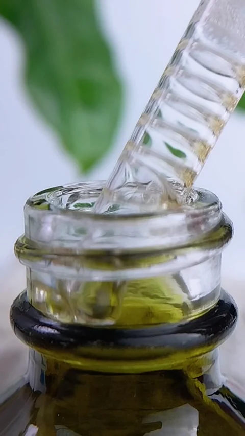 Front view of pipet filled with honey tea liquid bubbles in close up. Natur.. Stockbeeldmateriaal 340457111