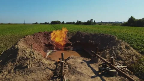 Front view of pit filled with substance and burning fire. Production of gas Stock Footage 213669333