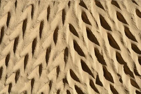 Front view of a plaster wall with a textured indentation pattern Stock Photos