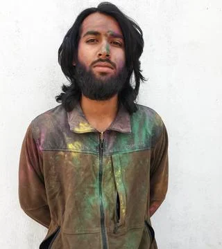 Front view portrait of good looking young man covered with multi colored holi Stock Photos