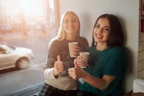 Front view portrait of two funny friends with thumbs up and looking to the ca Fotos de archivo