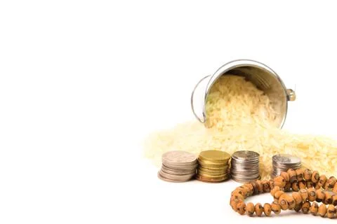 Front view of prayer beads, stack of coins and rice isolated on a white backg Stock Photos