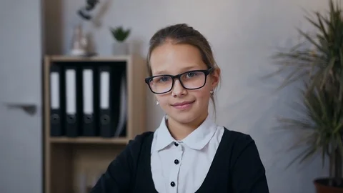 Front view of pretty high-spirited schoolgirl in glasses which posing on camera Stock Footage 124698272
