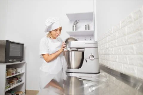 Front view of pretty joyful young woman, professional confectioner in white Stock Photos