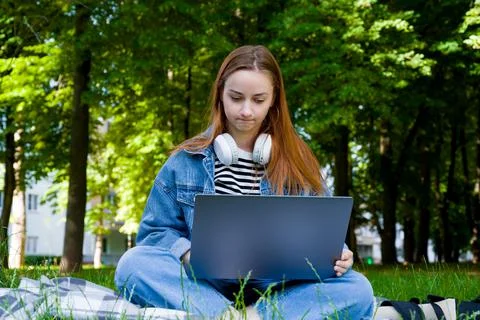 Front view on puzzled or unhappy female using laptop in the park.Student.remo Stock Photos