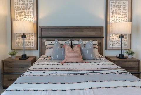 Front view of Queen size bed with wood headboard and two side tables Stock Photos