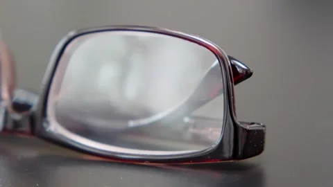 Front view of reading glasses with brown frames on a black office table. Cl.. Stock Footage 246482965