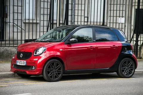 Front view of red and black smart car parked in the street Stock Photos