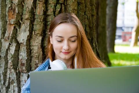 Front view on red haired caucasian female using laptop for study or remote wo Stock Photos