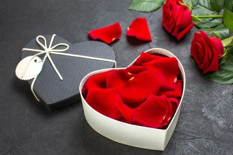 Front view red roses with box full of rose petals for valentines day on dar.. 写真素材