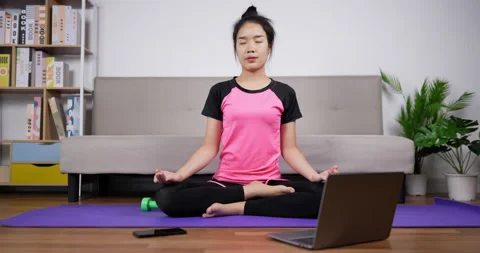 Front view of Relaxed asian young woman in sportswear is meditating in lotus  Stock Footage 200870727