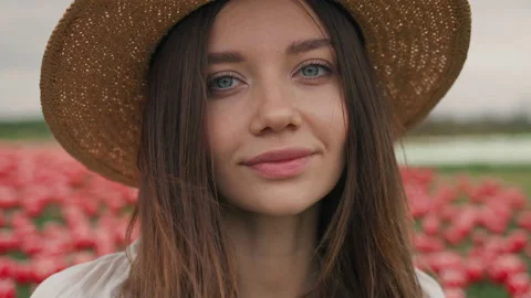 Front view of Romantic Young Lady in Straw Hat standing on Tulip's Field Stock-Footage 157551615