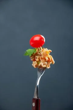 Front view rotini pasta with cherry tomato on fork on grey isolated backgro.. Stock Photos