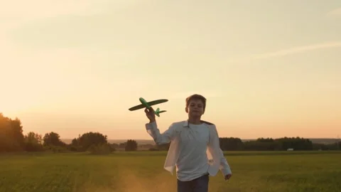 Front view of a running boy in a white shirt on a country road in a summer sunny Stock Footage 246651544