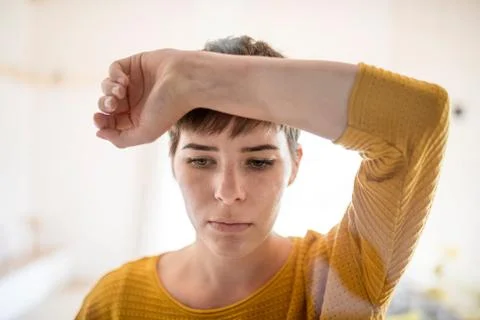 Front view of sad young woman standing indoors at home, close-up. Stock Photos