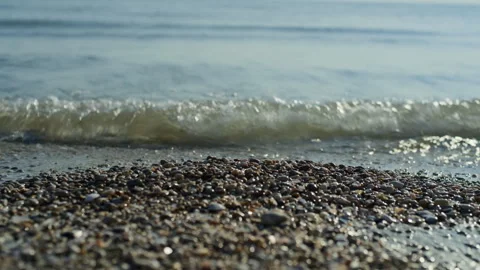 Front view of sea waves over wet pebbles on shoreline Stock Footage 315851747