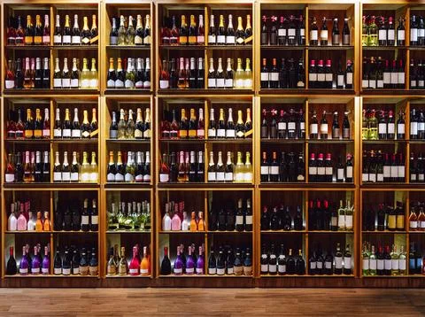 Front view of shelves with big selection of wine. Wine and champagne bottles Stock Photos