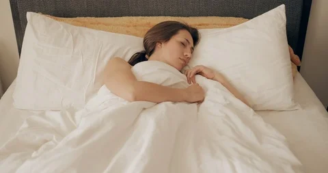 Front view of shocked young pretty woman oversleep and getting up fast while Stock Footage 127345703